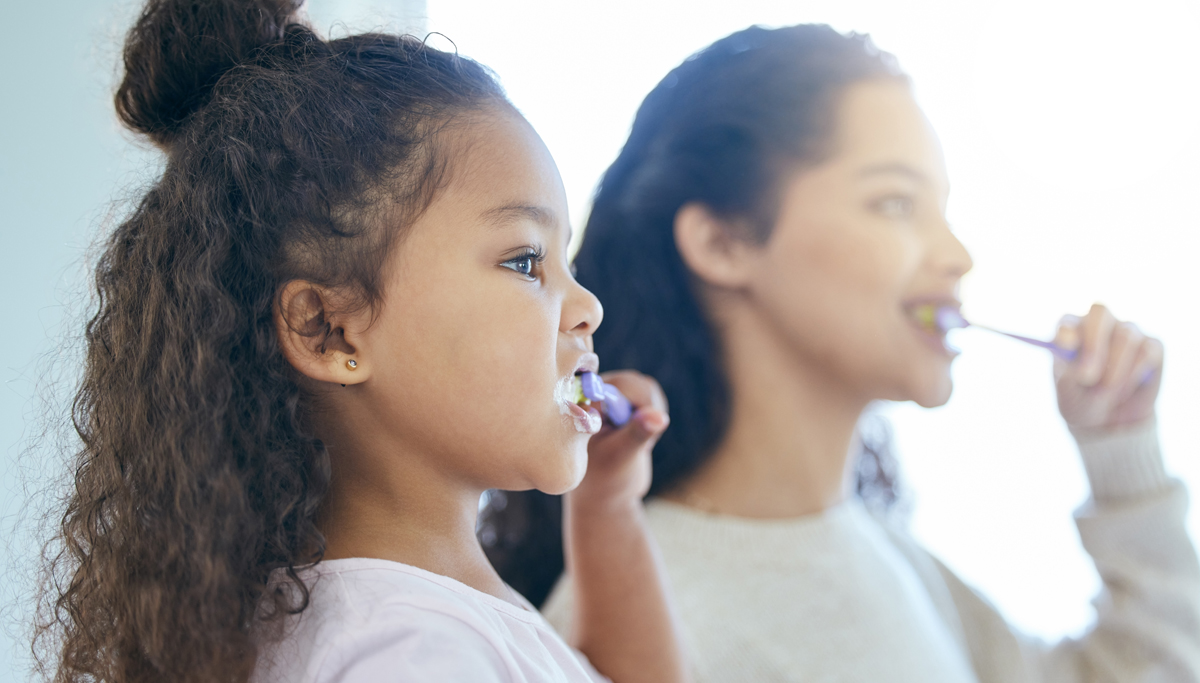 Mother and daughter brushing teeth