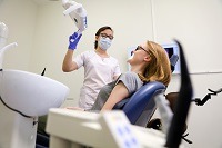 White woman in dental chair with white woman dentist