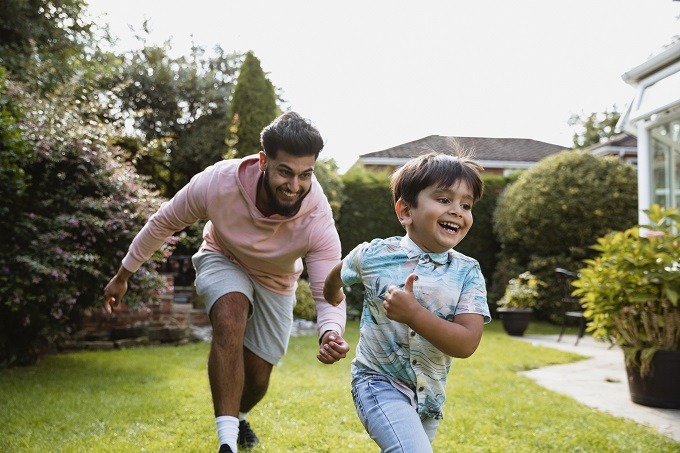 Father and son running in yard outside