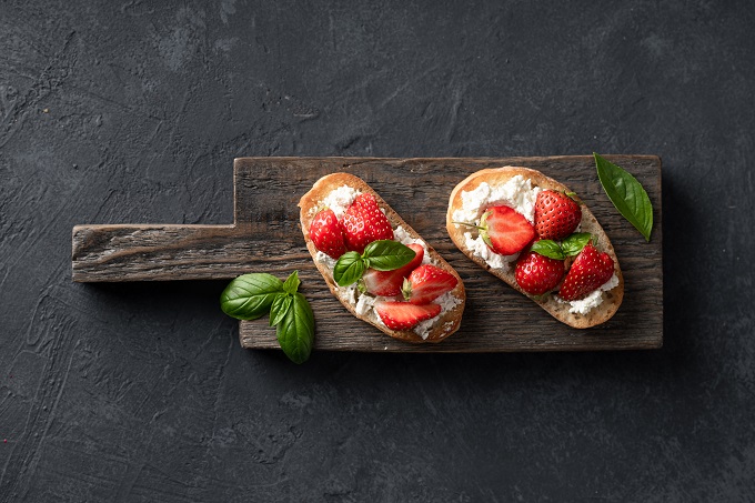 whole wheat toast with cream cheese and strawberries on top