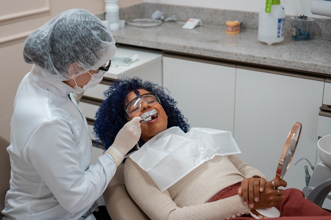 African American woman in dental chair being treated by a dentist