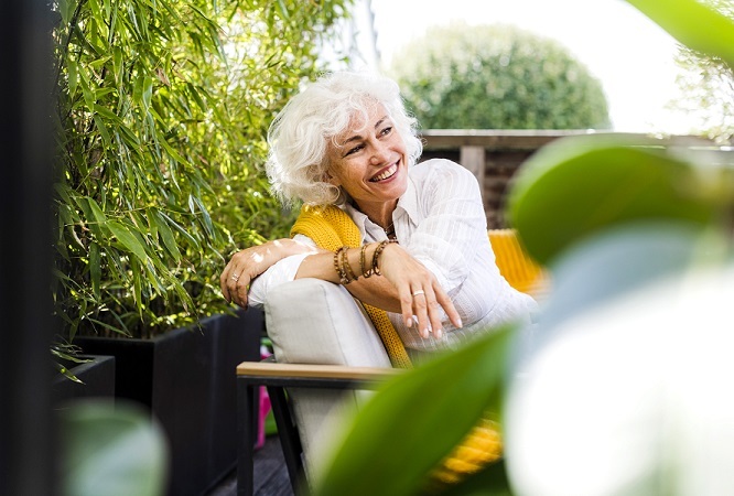 Older woman outside relaxing on patio chair