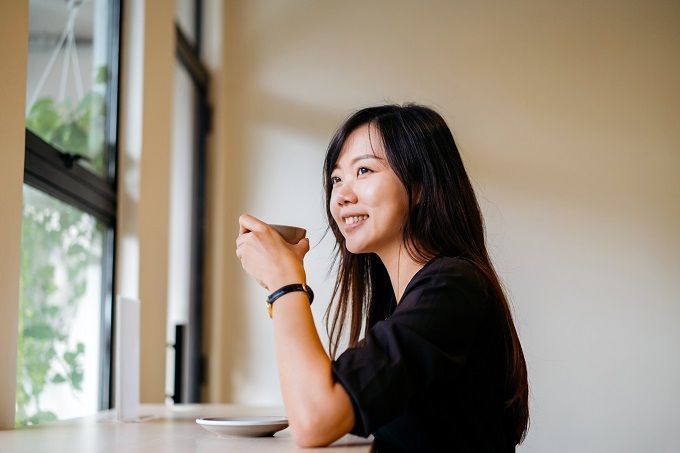 Woman taking a coffee break and looking out the window 