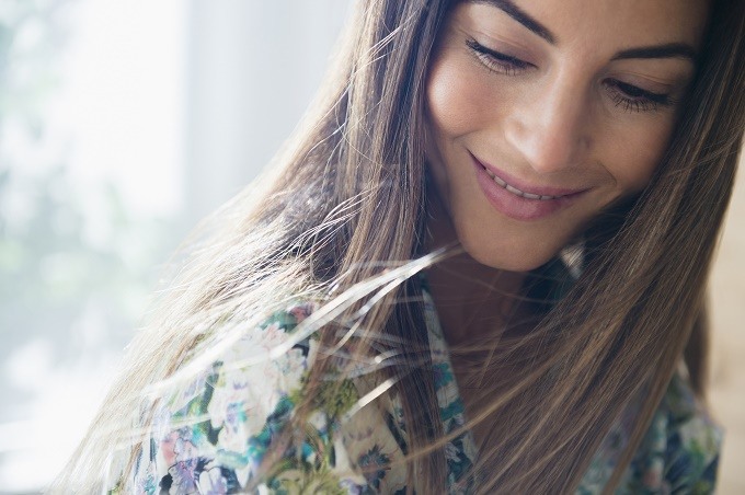 young white woman looking down and partially smiling