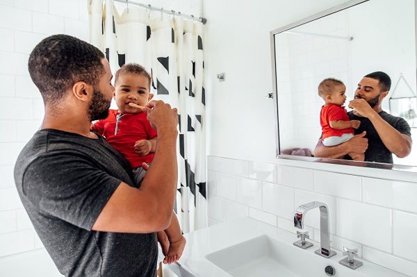 Dad brushing baby's teeth