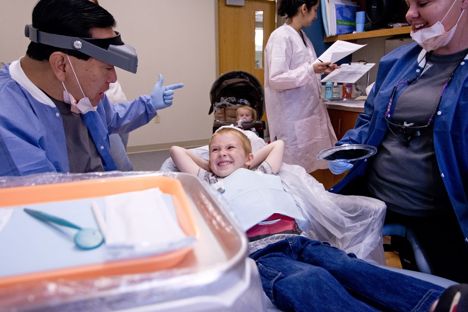 young girl in dental chair talking with dentist
