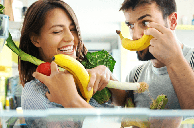Man and woman holding fruits and vegetables