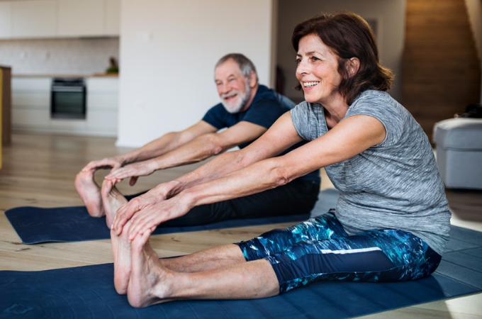 adults stretching on yoga mat