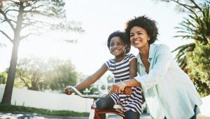 mom helping daughter on a bike