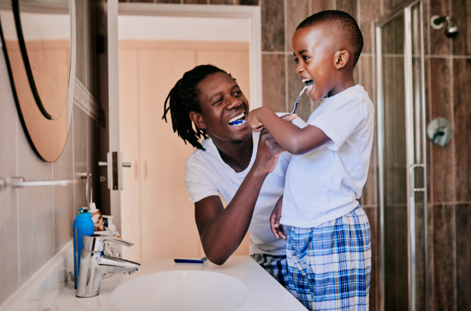 father and son brushing teeth