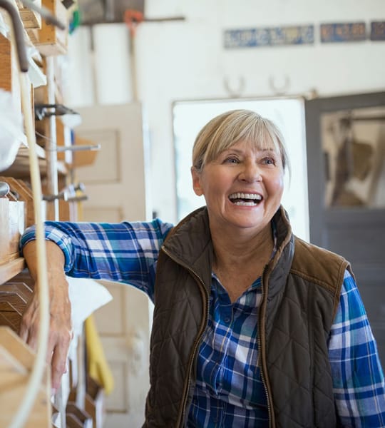 smiling woman leaning on a book shelf