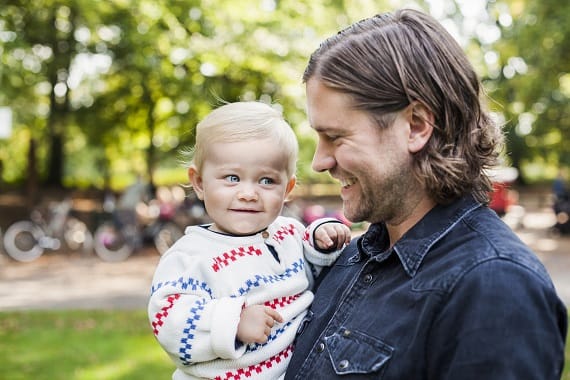 Happy father looking at baby girl in park