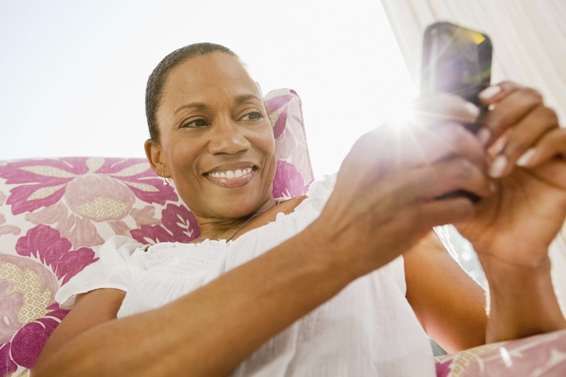 Woman sitting in chair and text messaging